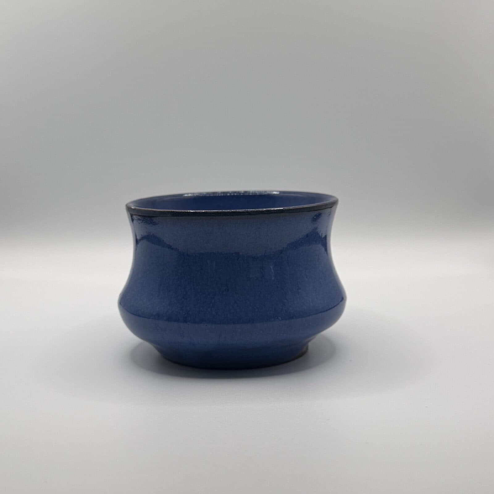 Tasse bleu cobalt tenue en main